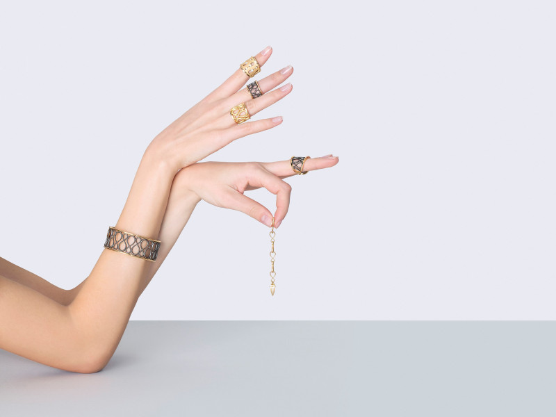 hands showing golden rings, a golden bracelet and a golden pendant
